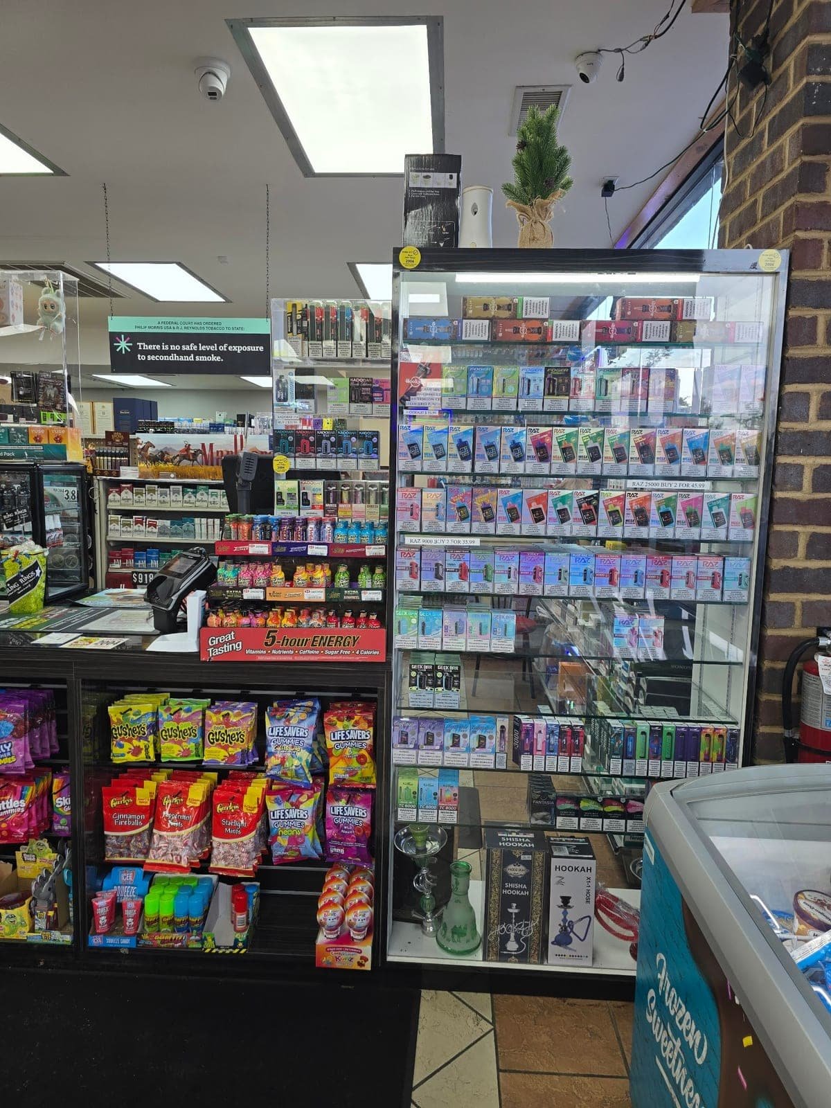 The lit display case of vapes and cigarettes behind the counter at Bent Creek Grocery